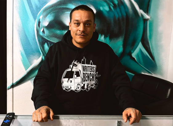 Man standing in front of a painting of a shark