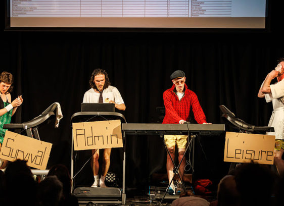 Four performers on a stage, running on treadmills