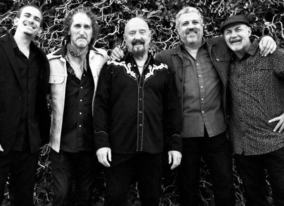 Five men standing close together pose for a band photograph (black and white image)