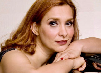 Tight crop of woman leaning on a piano