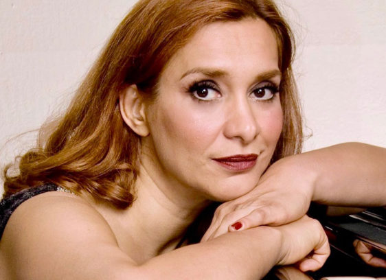 Tight crop of woman leaning on a piano