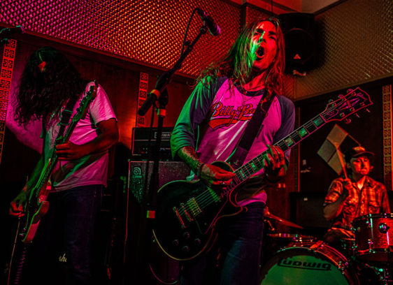 Musicians playing live under colored lights