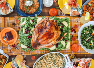 Full table packed with dishes, including turkey, photographed overhead