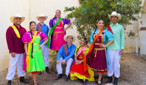 Group of people in brightly colored Mexican folk dance costumes