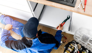 Plumber shot from overhead, working on a sink
