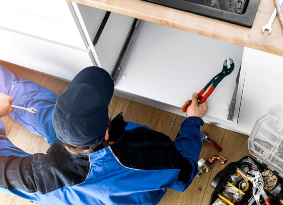 Plumber shot from overhead, working on a sink
