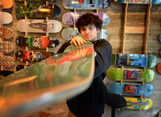 Young person pointing a skateboard directly at the camera