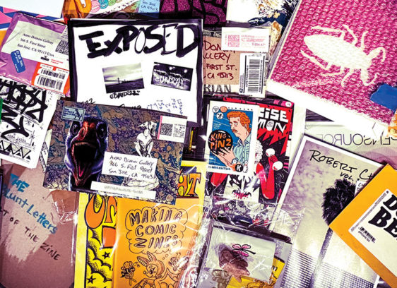 Copies of zines scattered on top of each other, photographed from above