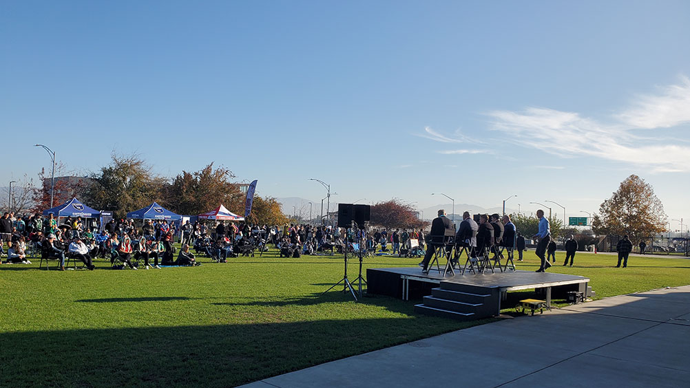 People watching a group of people sitting on a raised platform
