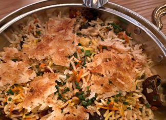 dish with crispy rice and vegetables in a silver bowl on a table