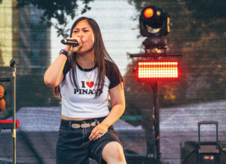 Woman singing into a microphone at an outdoor concert